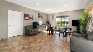 A spacious living area with a kitchen, dining table, and seating. - Americas Best Value Inn Byhalia (Byhalia)