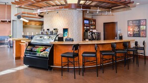 A bar area with a counter, a beverage dispenser, and several bar stools.