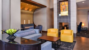 A modern lobby with a curved wall, seating area, and a fireplace.