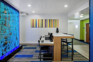 A modern office space with a long table, chairs, and a colorful abstract painting on the wall. - Holiday Inn Express & Suites Oroville Lake by IHG (Oroville)