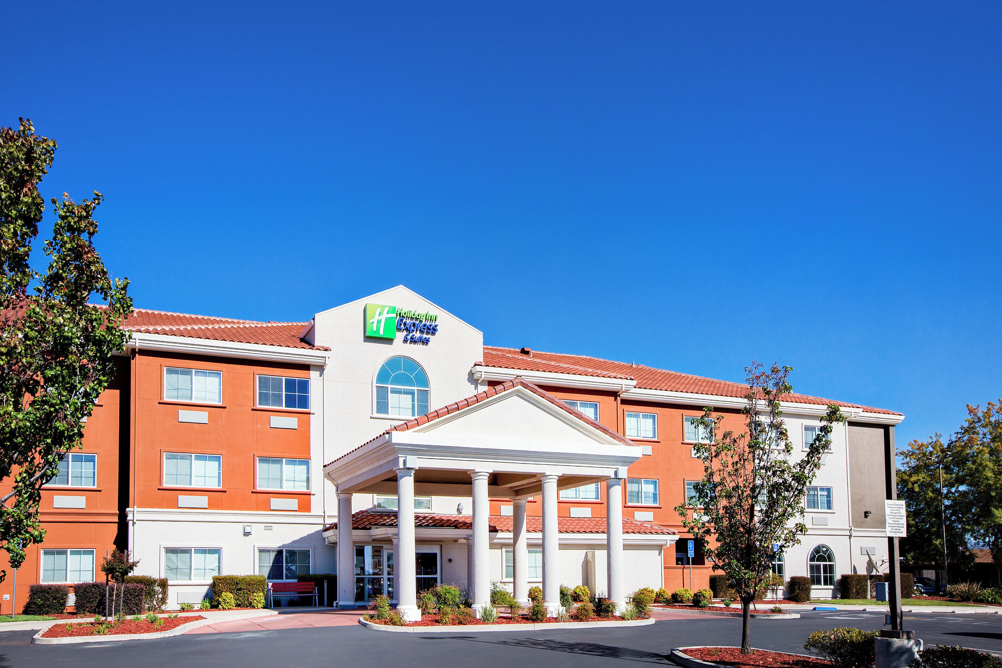 A Holiday Inn Express hotel with a central entrance, multiple windows, and a red-tiled roof.