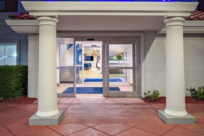 A hotel entrance with a glass door, a blue mat, and a tiled pathway leading to the interior. - Holiday Inn Express & Suites Oroville Lake by IHG (Oroville)