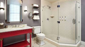 A modern bathroom with a glass-enclosed shower, a red vanity, and a large mirror.