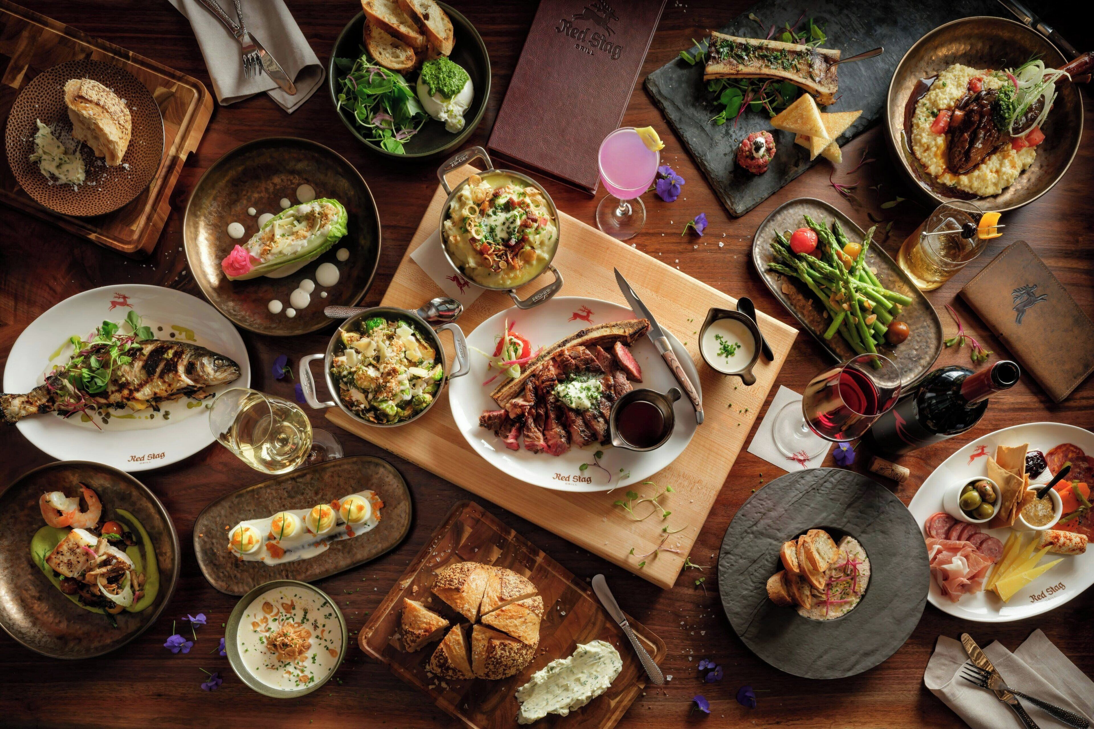 A variety of dishes and drinks on a wooden table, suggesting a dining setting.