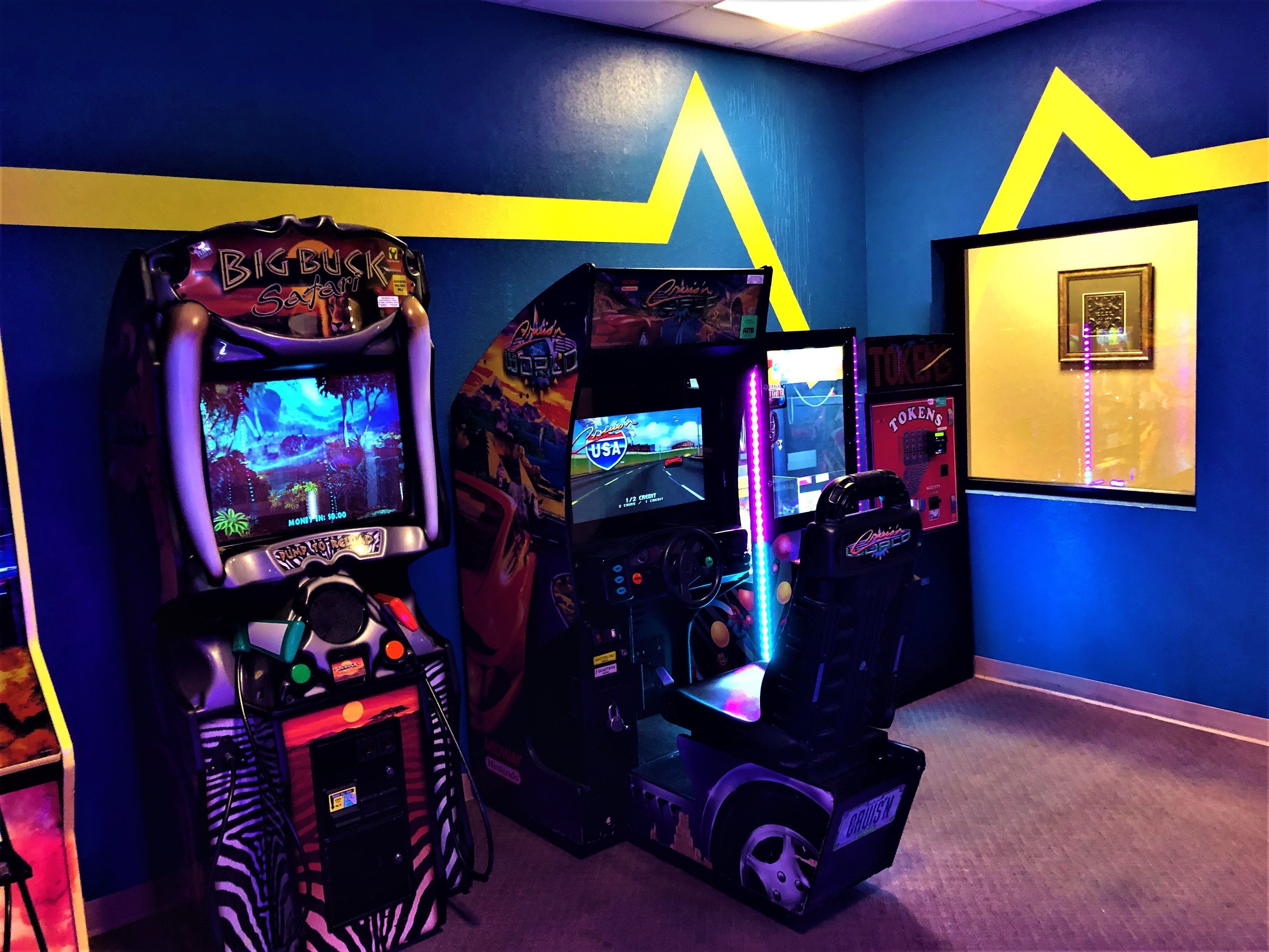 A gaming arcade with various racing and driving games, including 'Big Buckin' and 'Cruisin''.