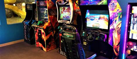 A row of arcade machines with various games, including 'Big Buck Stunt' and 'Midway'.