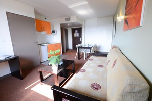 A compact living space with a kitchenette, a dining area, and a sofa. - Residhotel Lyon Lamartine (Tassin-la-Demi-Lune)