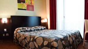 A hotel room with a bed, a nightstand, a telephone, and a painting on the wall. - Residhotel Lyon Lamartine (Tassin-la-Demi-Lune)