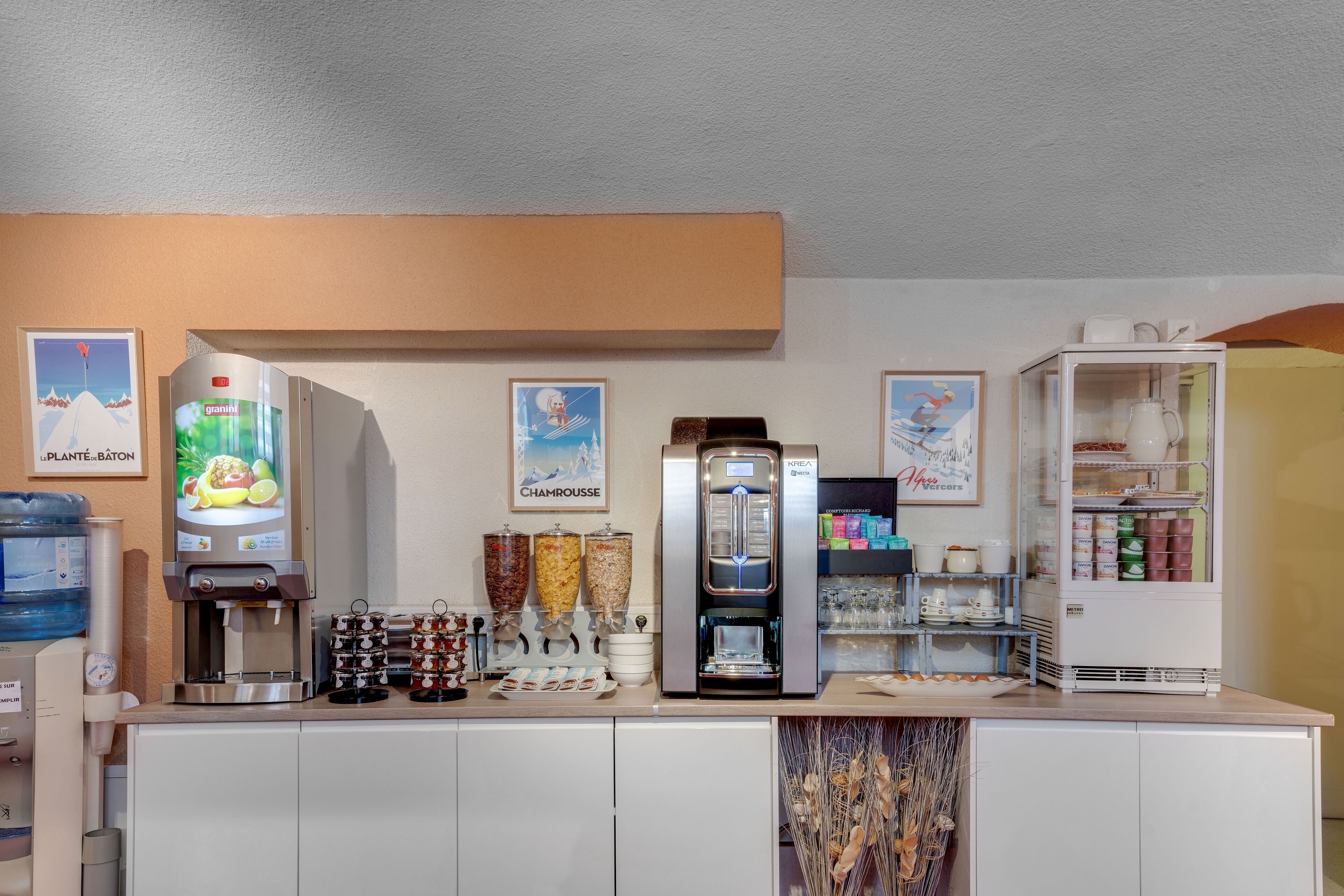 Una estación de autoservicio para bebidas con varios dispensadores, incluyendo una máquina de café y un dispensador de agua.