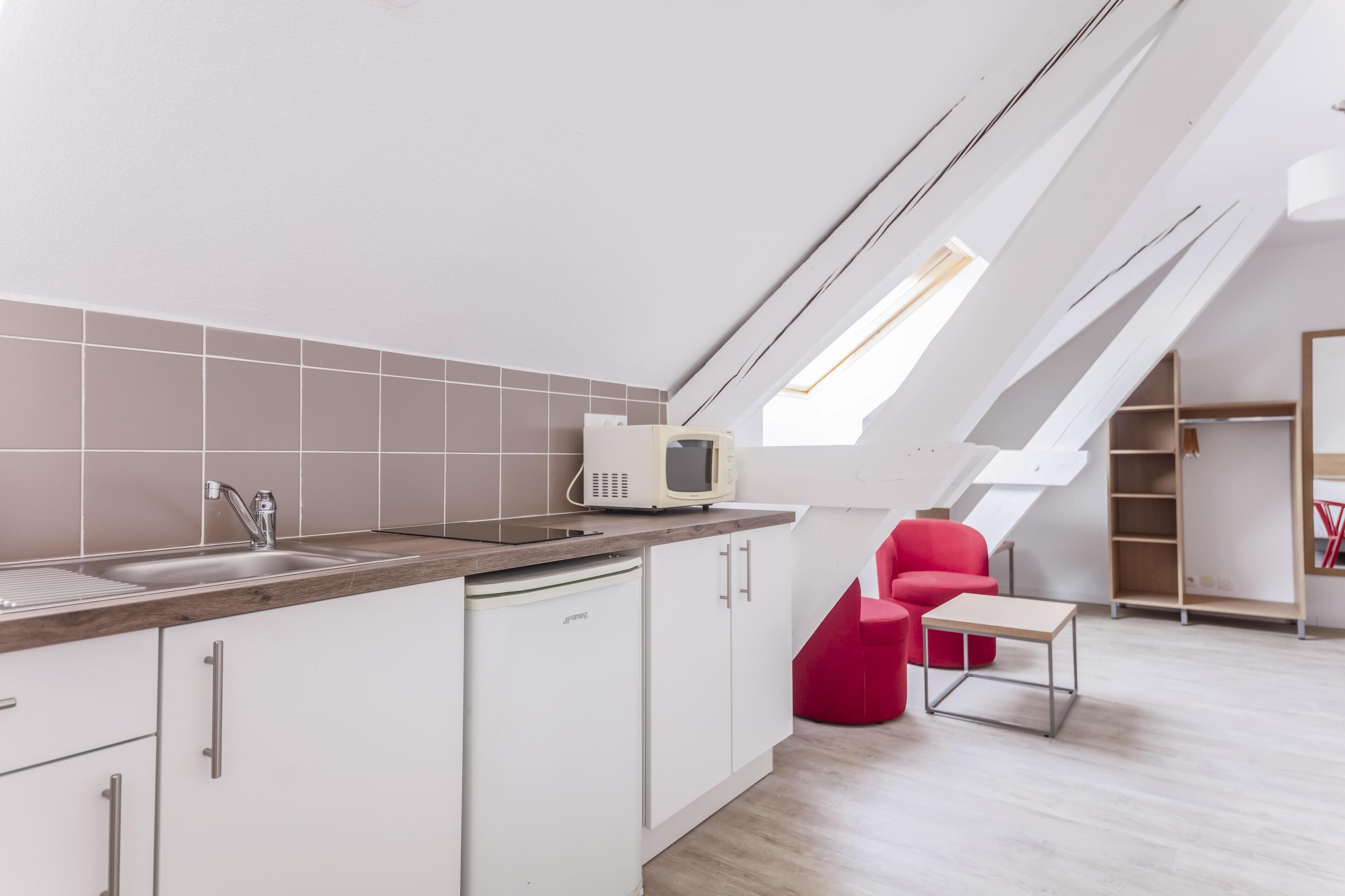Eine moderne Küche mit integriertem Mikrowellenherd, weißen Schränken und einer Holz Arbeitsplatte.