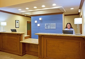 Mostrador de recepción de Holiday Inn Express con pared azul y un cartel enmarcado.