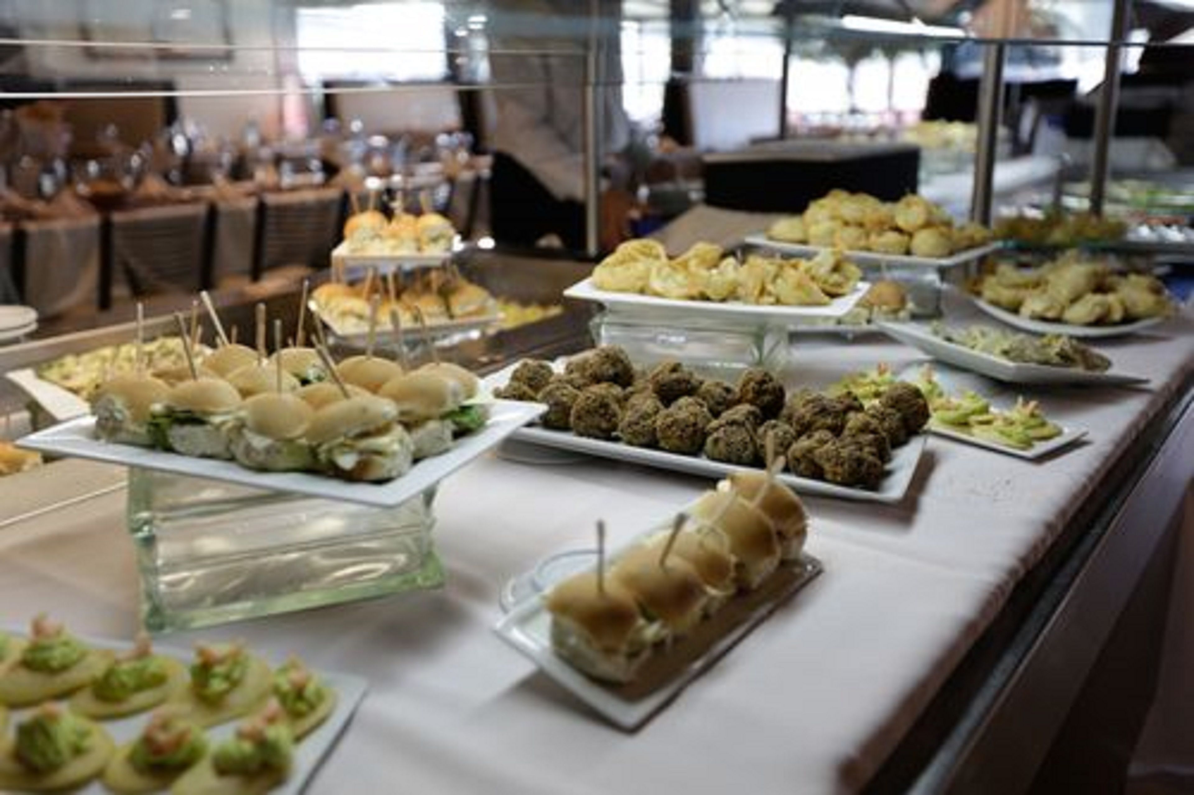 Un buffet proposant une variété de plats présentés sur des plateaux en verre.