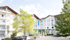 Un hotel con varios pisos, balcones y una recepción.
