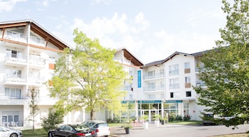 Um hotel com vários andares, varandas e uma área de recepção.