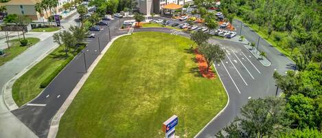 A Comfort Inn hotel with a parking lot, a grassy area, and a road with directional arrows.
