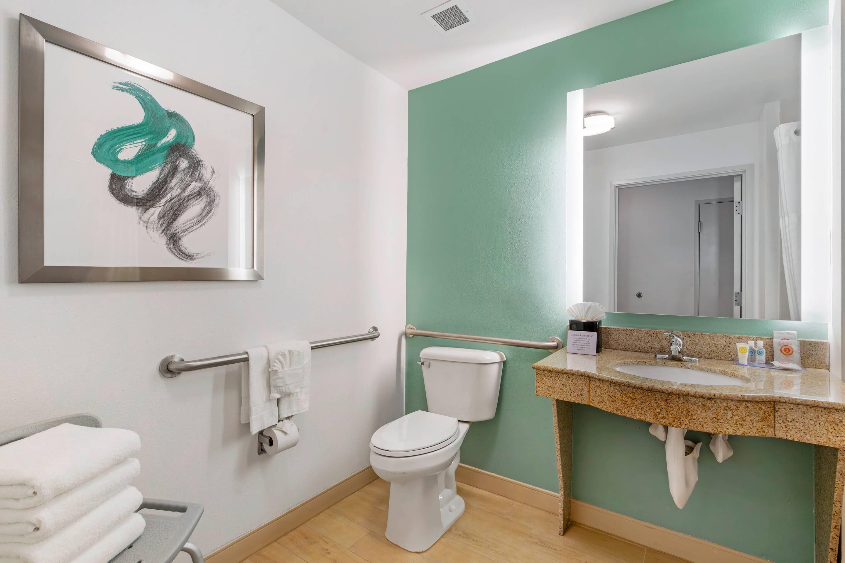 Een badkamer met toilet, wastafel en handdoekhouder.