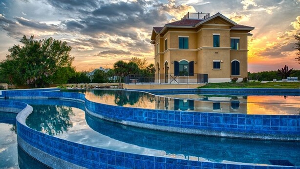 A two-story house with a swimming pool in front. - Comfort Inn & Suites (Port Charlotte)