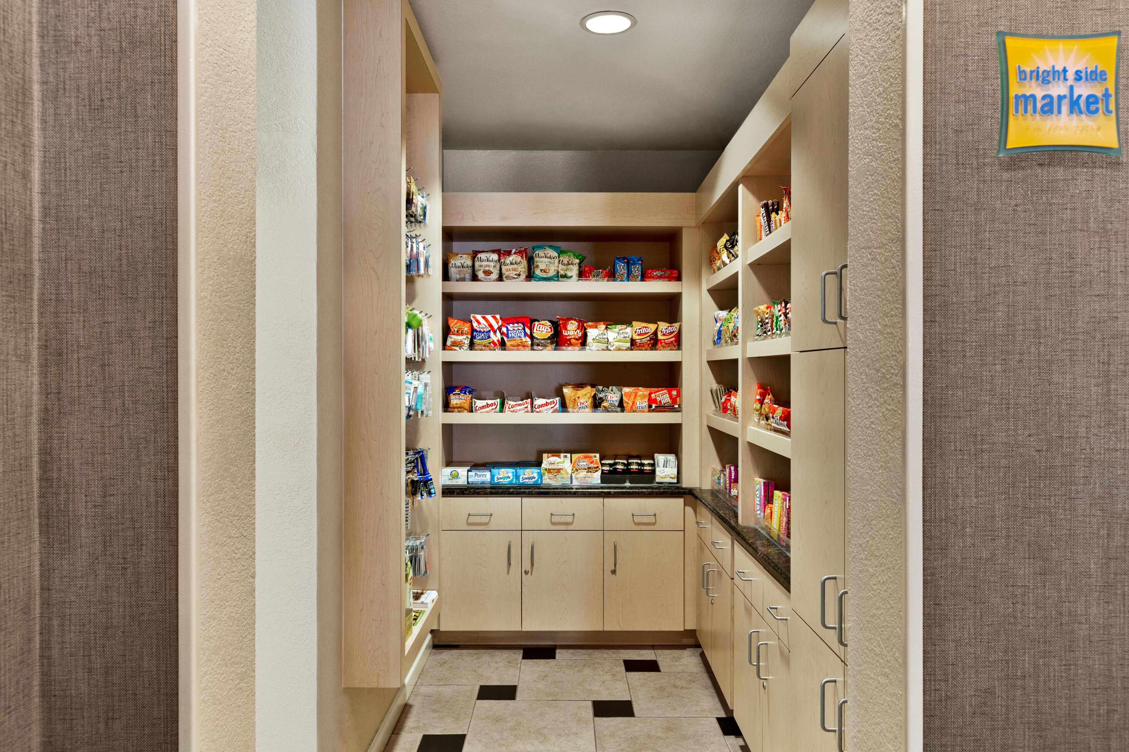 A narrow pantry with shelves stocked with various food items and a sign indicating it's part of the Bright Side Market.