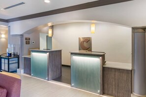 A reception area with two counters, a coffee machine, and a large mirror. - Comfort Inn & Suites (Port Charlotte)