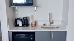 A compact kitchen with a microwave, coffee maker, and sink. - Comfort Inn & Suites (Port Charlotte)