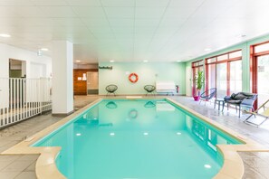 A swimming pool with a lifebuoy, chairs, and a whiteboard in a well-lit indoor area. - Cerise Carcassonne Sud (Carcassonne)