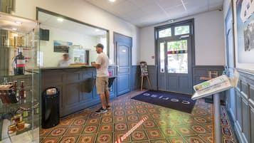 A bar area with a counter, a trash bin, and a display of bottles.