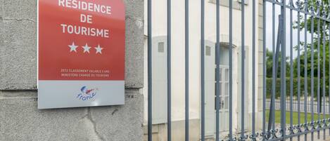 A sign on a wall that reads "Résidence de Tourisme" with a logo and text indicating a 2012 award by the French Ministry of Tourism.