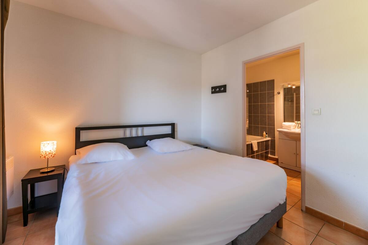 Ein ordentlich bezogenes Bett mit weißen Leinen in einem Hotelzimmer.