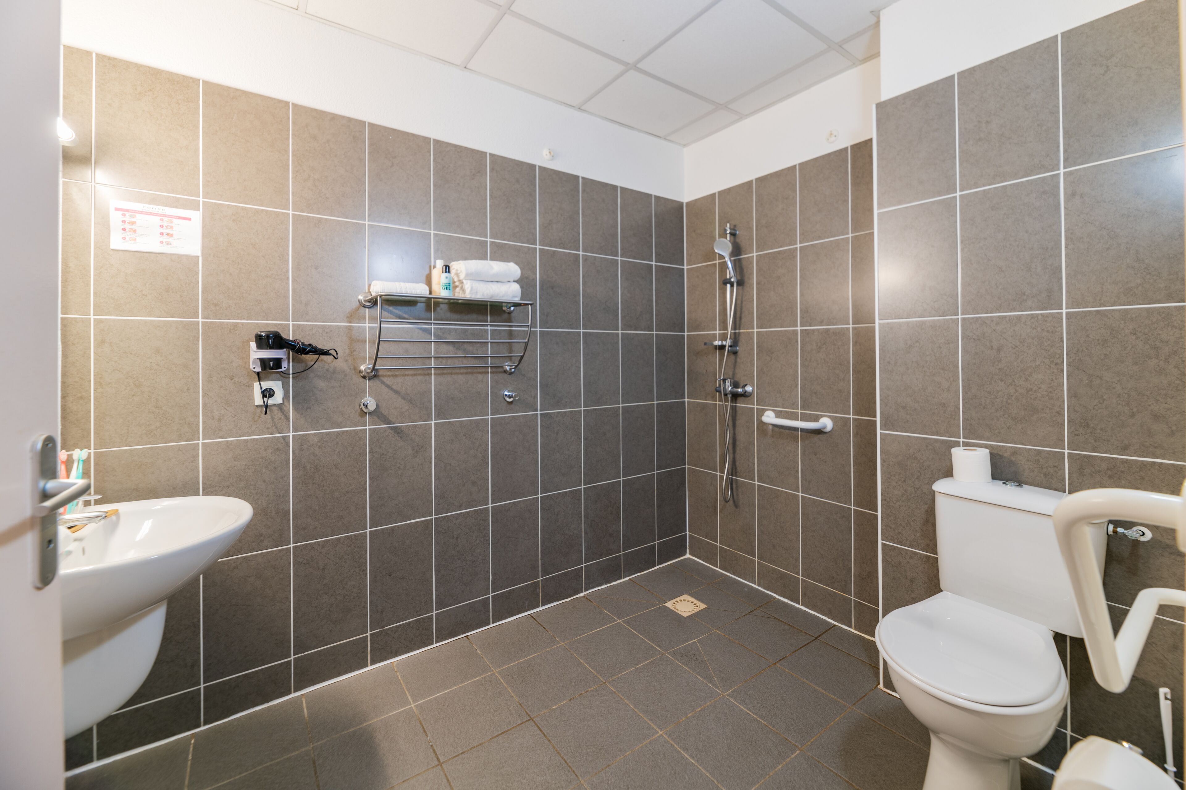Un baño con lavamanos, inodoro y ducha.