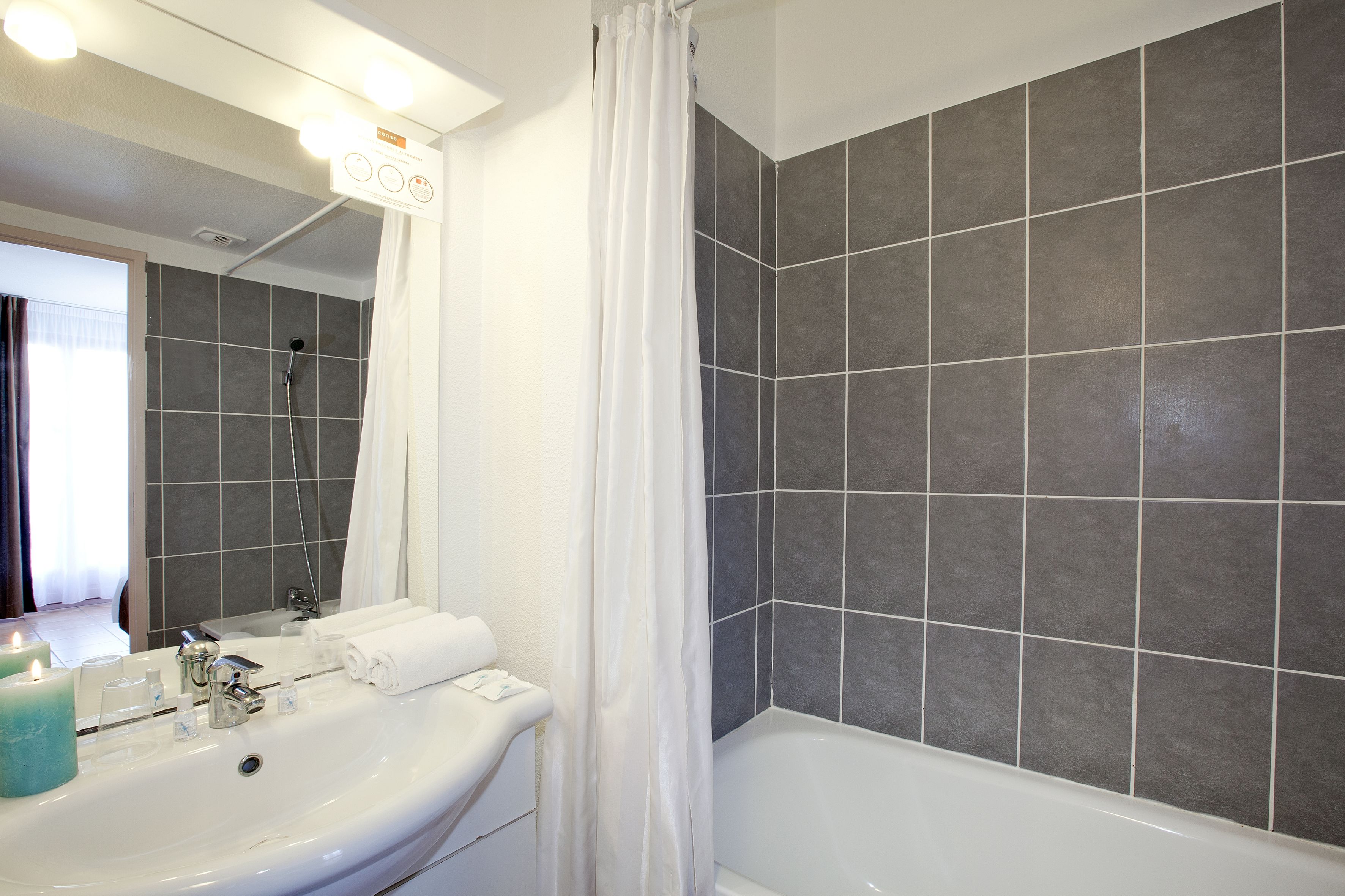 A bathroom with a white sink, mirror, and bathtub.