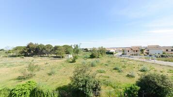A residential area with houses, a road, and a grassy field.