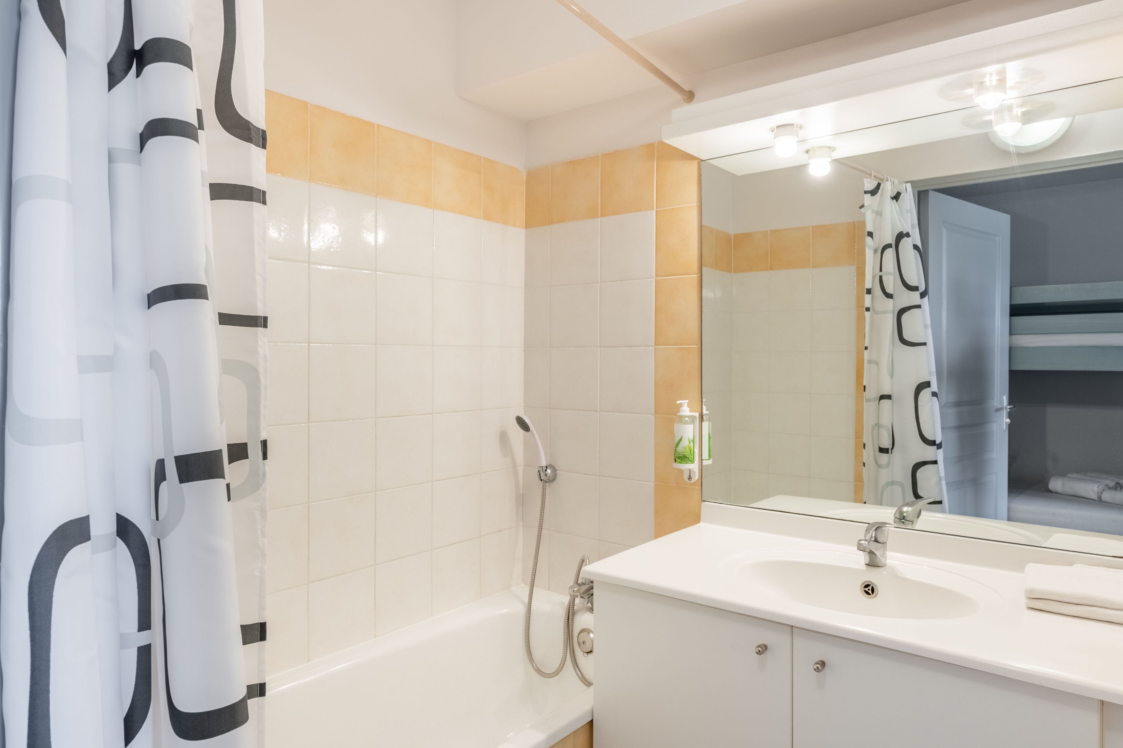 Une salle de bain moderne avec une baignoire, un lavabo et un miroir.