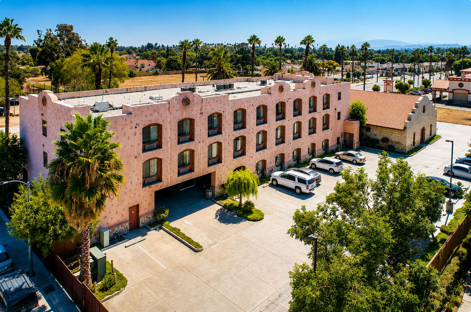 A multi-story building with a parking lot in front.