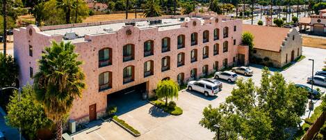A multi-story building with a parking lot in front.