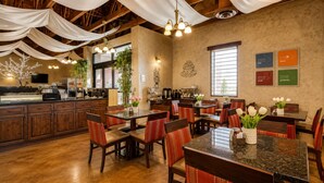 A restaurant with wooden furniture, a bar area, and a kitchen visible in the background.