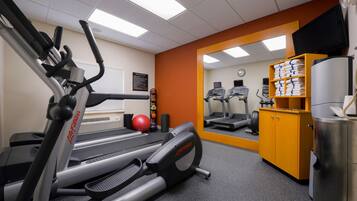 A gym with treadmills, a stationary bike, and a mirrored wall.