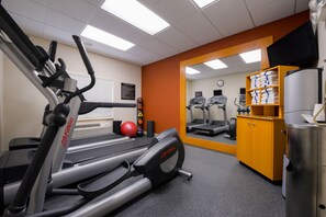 A gym with treadmills, a stationary bike, and a mirrored wall.