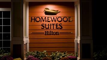 A hotel entrance with the sign "Homewood Suites Hilton".