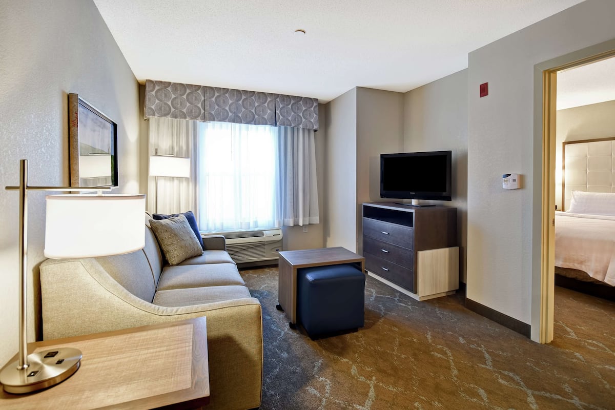 Een hotelkamer met een bank, een televisie, een bureau en een bed.