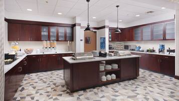 Una cocina moderna con una isla central, electrodomésticos integrados y un suelo estampado.