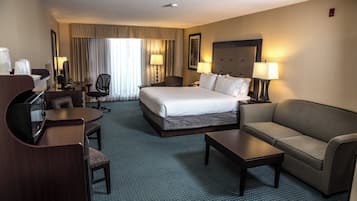 Une chambre d’hôtel avec un grand lit, un canapé, un bureau et une chaise.