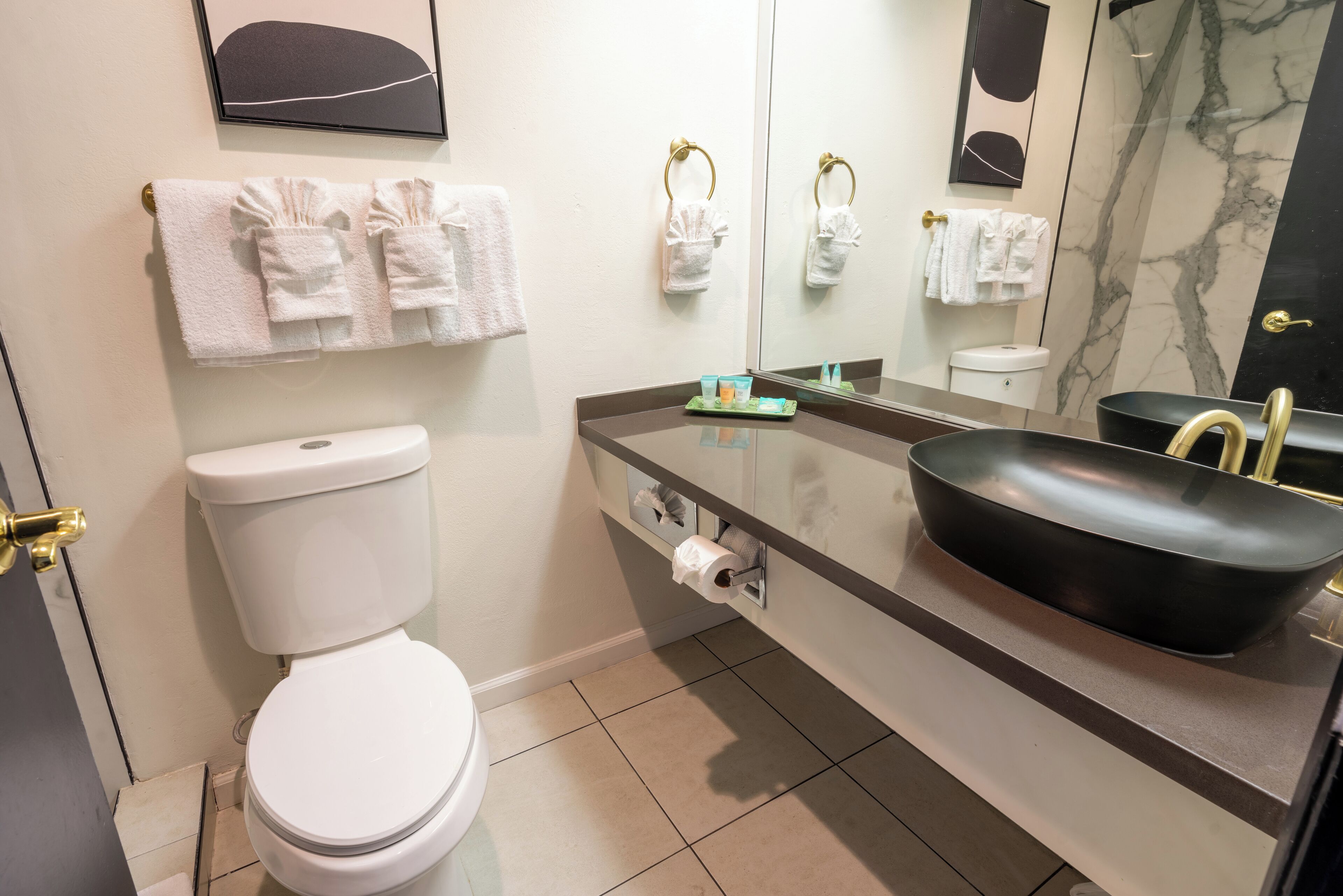 A modern bathroom with a toilet, sink, and towel rack.