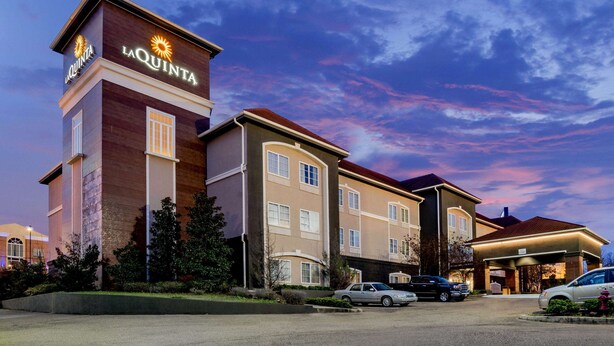 Ein Hotel mit einem gut sichtbaren 'La Quinta'-Schild, mehreren Parkplätzen und einer gepflegten Grünanlage.