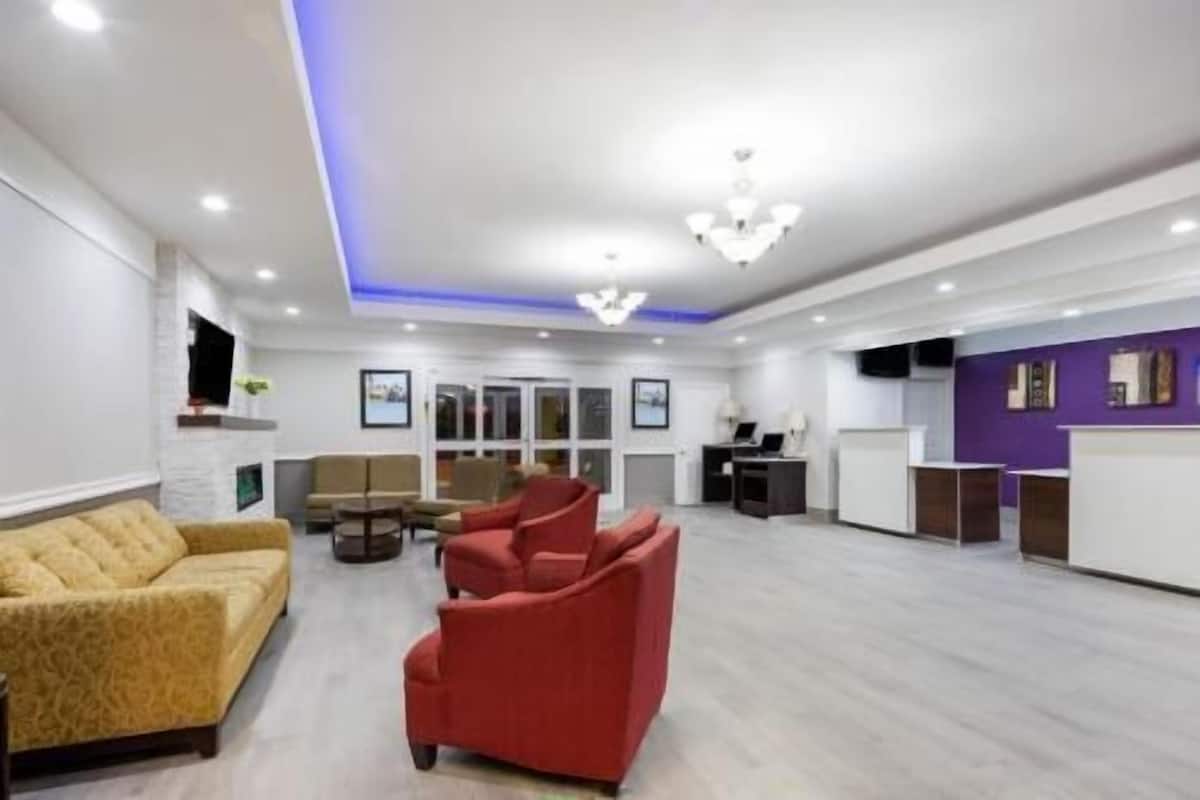 A spacious lobby with a reception desk, sofas, and a chandelier.