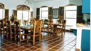A dining area with a large table and chairs, a ceiling fan, and a tiled floor. - Casa de San Pedro Bed & Breakfast (Hereford)