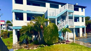 Un edificio de dos pisos con fachada azul y blanca, una escalera central y un letrero que dice "LOBBY".