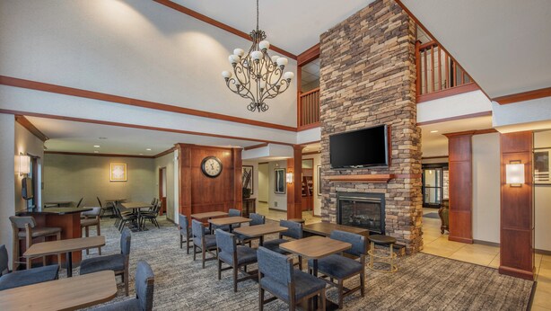 A spacious lobby with multiple seating areas, a fireplace, and a large TV screen.