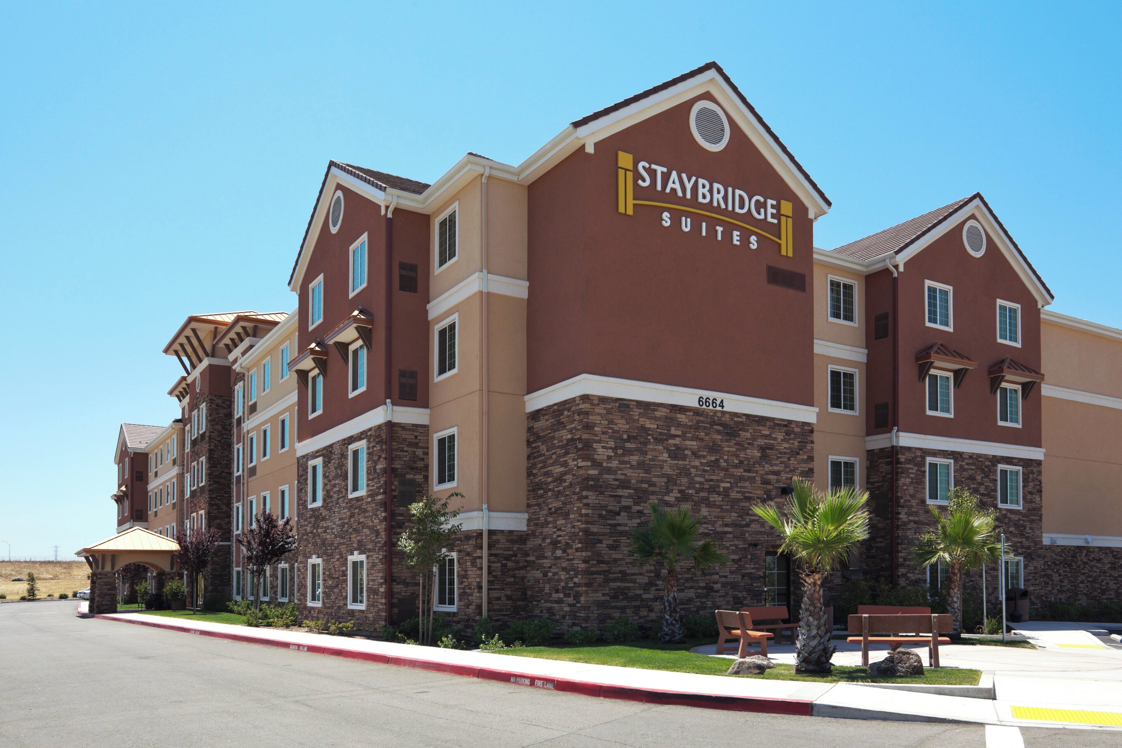 A Staybridge Suites hotel with a brick facade, multiple windows, and a fire lane.