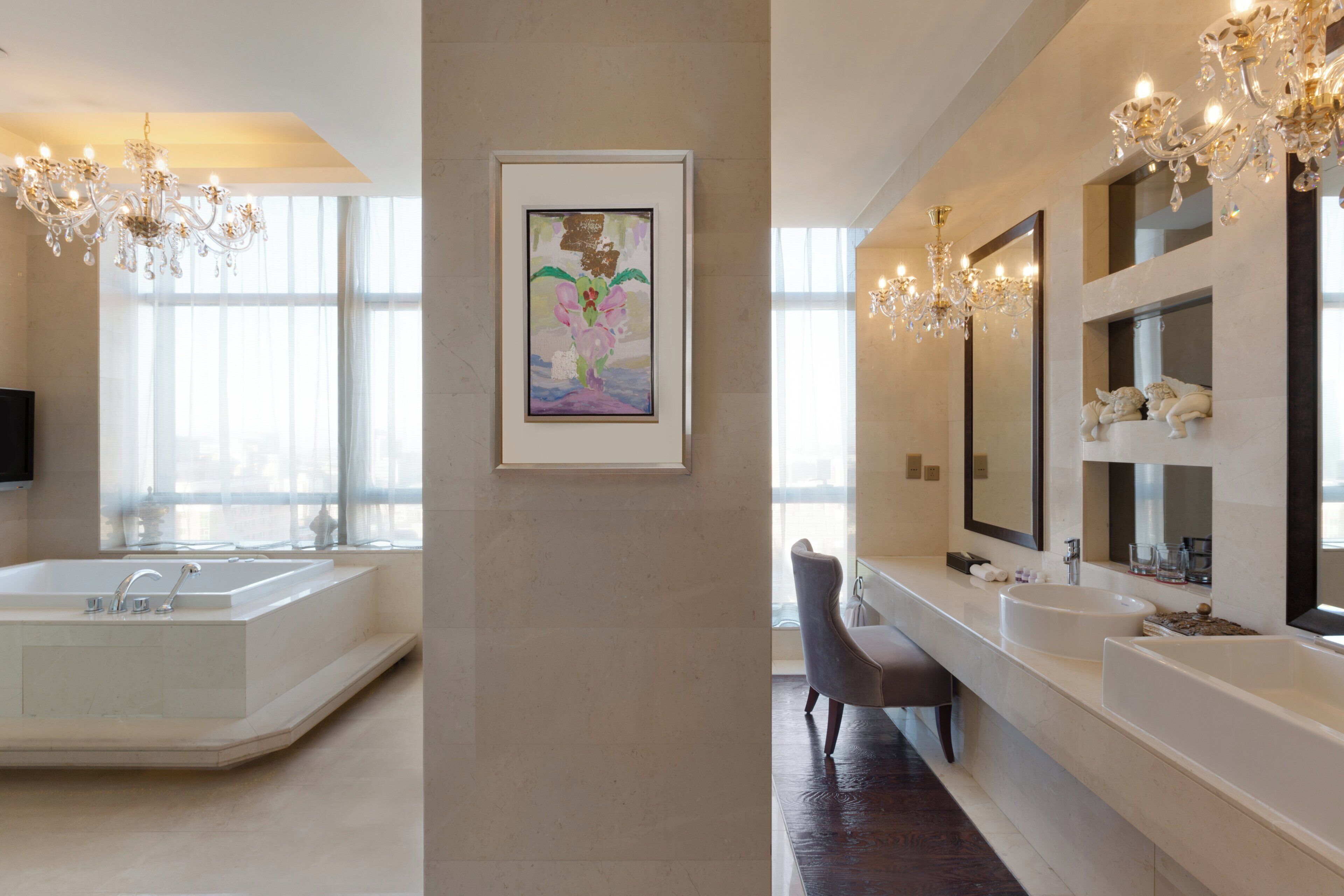 A modern bathroom with a large bathtub, two sinks, and a vanity mirror.