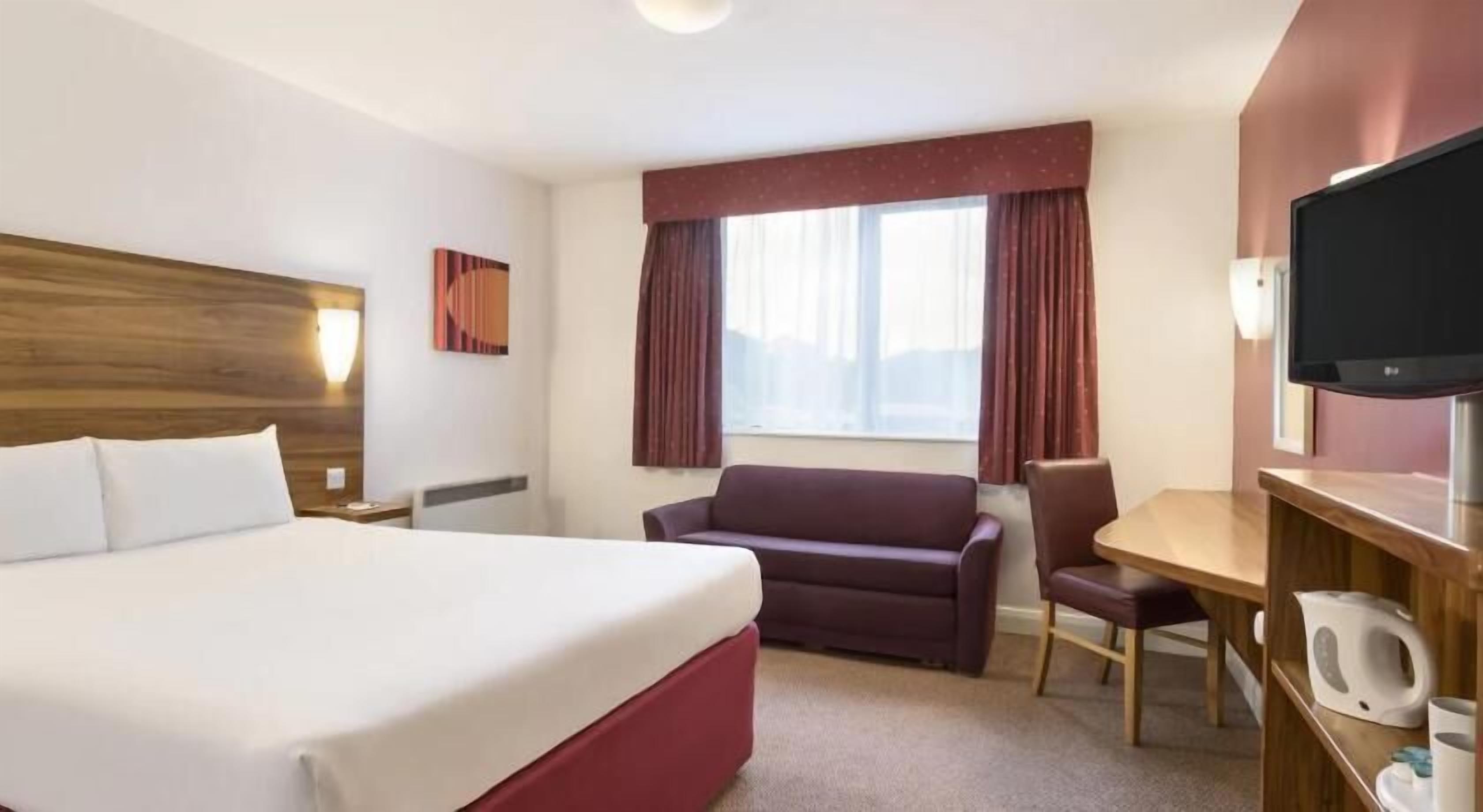 Hypo-allergenic bedding, desk, laptop workspace, blackout drapes